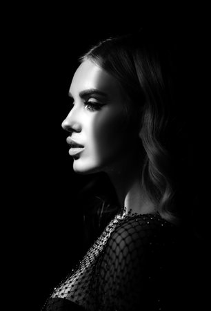 Romantic profile portrait of beautiful female model. Charming elegance model with sensual seductive look. Beauty sexy female face with dramatic studio light. Sexy girl.の写真素材
