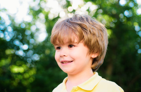 Portrait of little boy. Concept of kids face close-up. Head shoot children portrait in summer nature...