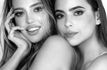 Portrait of two cheerful young women. Two beautiful young women with perfect skin in the studio. Skincare facial treatment, beauty salon.の写真素材