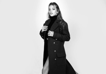 Vogue female coat. Fashionable woman on isolated studio background. High fashion portrait of young elegant woman, studio shot. Pretty young lady in a fashion pose.の写真素材