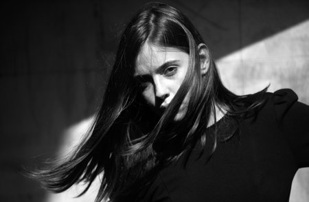 Fashionable woman on the street, fashion street style. Hair movement of sensual brunette woman.