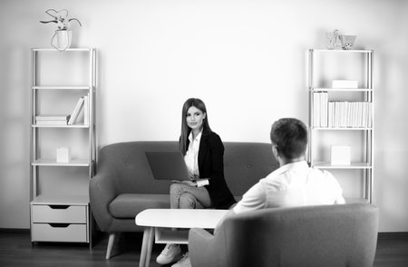 Talking business people. Young business couple wear casual clothing relaxing in office working with computer laptop.の写真素材