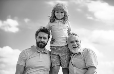 Portrait of grandfather father and funny son child outdoor on sky. Fathers day. Men in different...