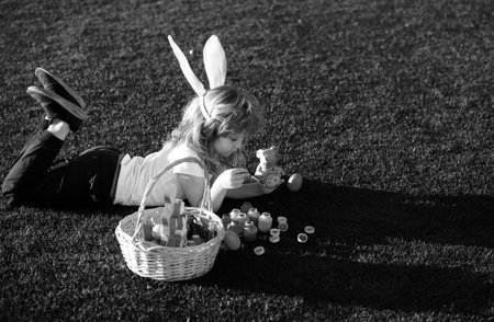 Happy easter bunny child boy painting eggs. Spring kids holidays concept.の写真素材