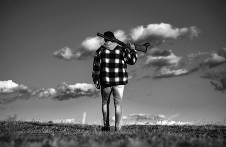 Poacher in the Forest. Man holding shotgun. Hunter man. Hunting period, autumn season. Hunter with a hunting gun and hunting form to hunt in forest.の写真素材