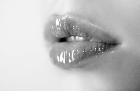 Natural beauty lip care. Female lips with pink lipstick. Sensual tenderness womens open mouths. Red lip with glossy lipgloss. Close up, macro with beautiful mouths. Sensual lips of a young woman.の写真素材