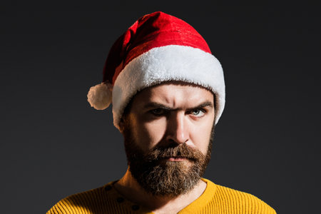 Handsome bearded man in Santa hats. Close up face of serious Santa. Man celebration Happy New Year and Christmas winter holiday. Portrait of father Santa. Man with beard in Santa costume.の写真素材