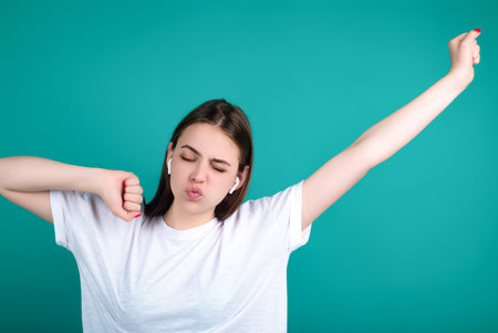 Excited Woman listening to music with earphones. Girl with wireless earphones. Listening music in earphone, studio. Earphones in ear. Woman using headphones. Ear buds, wireless earbud earphone.の写真素材