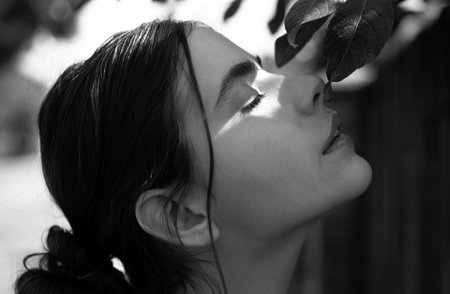 Beautiful girl face closeup, outside portrait of young woman. Summer romantic casual woman , profile portrait. Young woman on sunny spring day.の写真素材