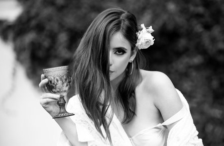 Portrait of a gorgeous sexy young brunette woman having wine fun. Retro vintage girl style.の写真素材