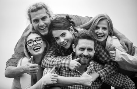 Happy friends from diverse cultures and races taking selfie with thumb up. Youth and friendship concept. Group of friends laughing out loud outdoor, good and positive mood.の写真素材