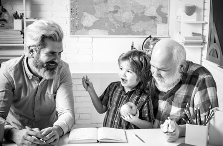 Fathers day. Family relationship between grandfather father and son. Grandpa teaching school boy learning to write and read. Portrait grandpa and grandson playing and learning.の写真素材
