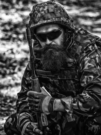 Ukraine war. Tired soldier. Military conflict, geopolitical concept. Army soldier with assault rifle and combat helmet.の写真素材