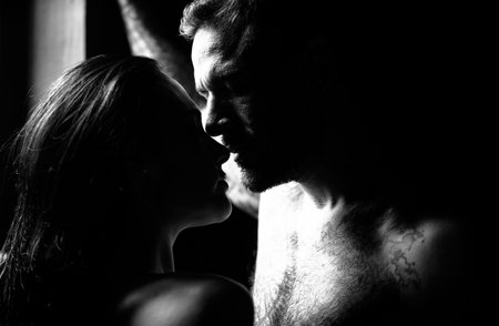 Close-up of young romantic couple is kissing each other. Sexy elegant couple lovers in the tender passion. Portrait of lovely sexy couple in love. Man kiss sensual woman. Romantic couples embraces.の写真素材