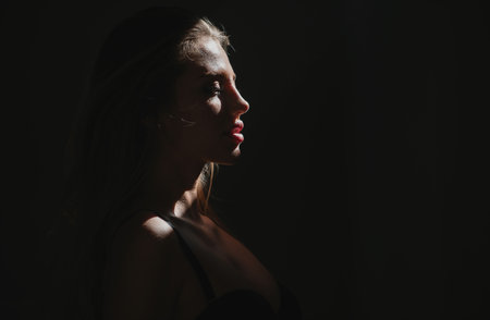Sexy gorgeous woman with shadows on beautiful face on black studio. Sensual girl.