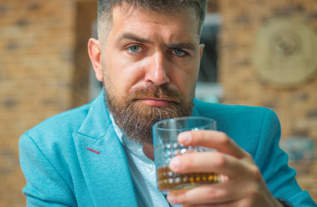 Bearded man getting haircut by hairdresser and sitting in chair at barbershop. Bearded client...