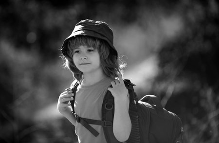 Child boy with backpack hiking in scenic mountains. Boy local tourist goes on a local hike.の写真素材