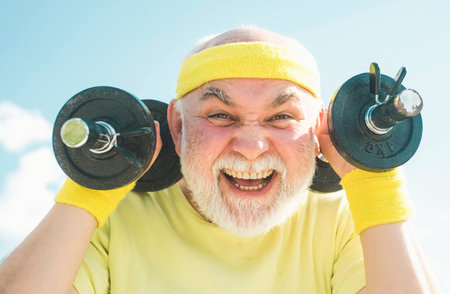 Senior man in his seventies training and lifting weigh. Health club or rehabilitation center for...