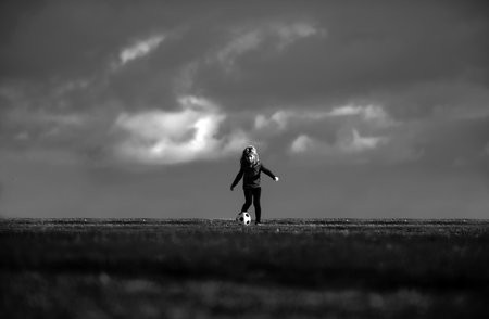 Kid playing soccer, happy child enjoying sports football game, kids activities, little soccer player. Active sporty kid soccer.の写真素材