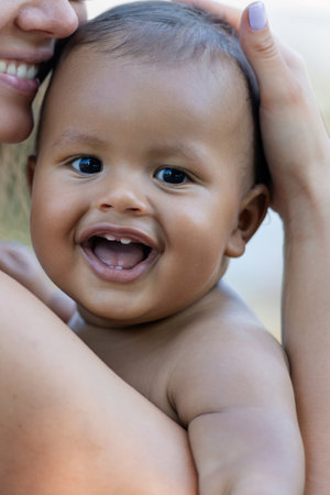 Close up portrait of mother hugging multiracial baby. Mom hug Biracial child. Closeup face of Mother...