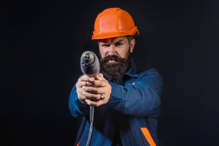 Portrait worker in construction helmet. Builder foreman or repairman in builder uniform. Worker in studio. Construction manager, builder in helmet. Male builder engineer.の写真素材