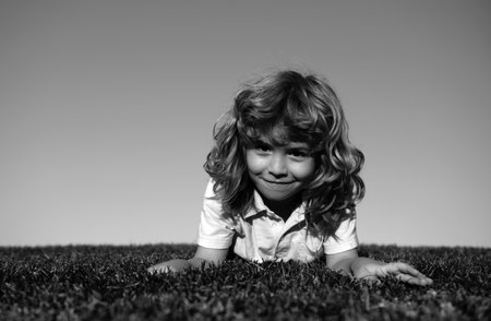 Little cute boy laying on grass. Kids exploring nature, summer.の写真素材