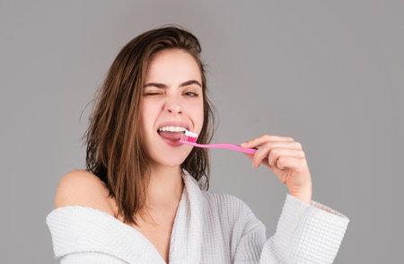 Beauty portrait of a happy beautiful woman brushing her teeth with a toothbrush isolated background. White tooth.の写真素材