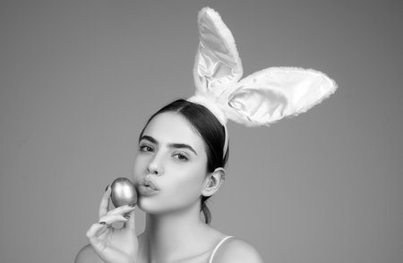 Bunny girl with easter egg. Rabbit girl with color egg. Woman in rabbit ears. Egg hunt.の写真素材