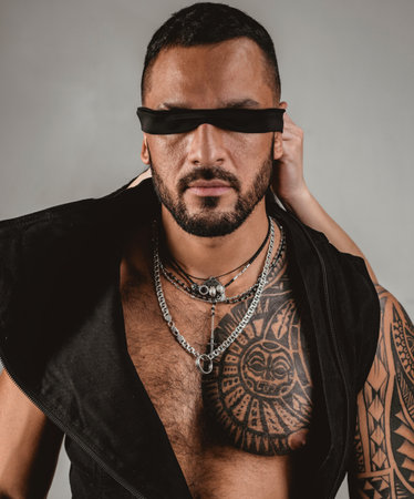 Confident attractive man with ribbon on eyes with rope. Trust concept. Muscular macho man with athletic body.の写真素材