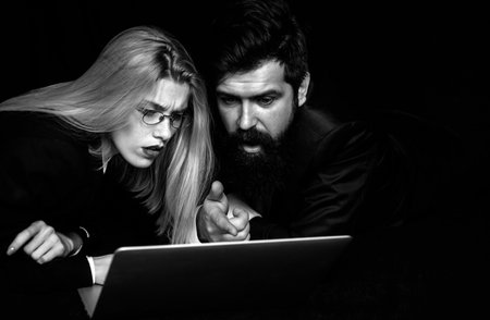 Two business partners working with laptop together. Couple guy and girl surfing internet in laptop. Portrait of business people.の写真素材