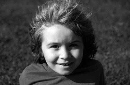 Kids portrait, close up cute child on grass in park.