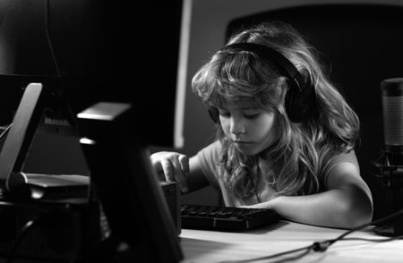 Child plays a video game on the pc computer screen. Gamer play computer games. Neon lighting. Social network for kids.の写真素材