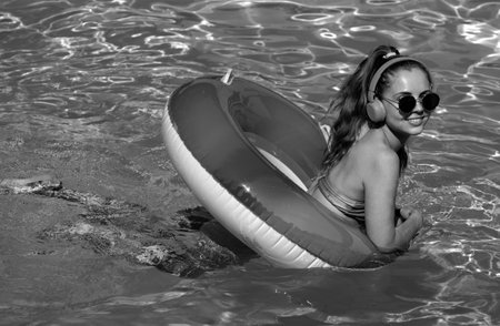Summer young woman. Enjoying suntan. Woman in swimsuit on inflatable circle in the swimming pool.