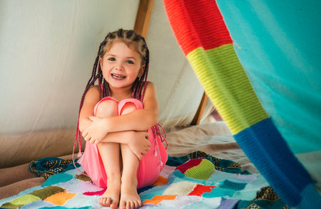 Girl playing in tent. Child camping at campground outdoor. Having fun outside.の写真素材