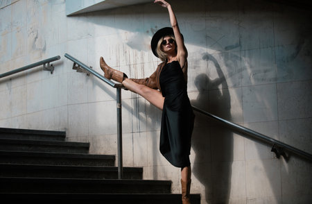 Flexible stretch fit woman body. Young girl doing stretching workout. Fitness model exercising in morning outdoors. Fashion vogue, urban street sport.の写真素材