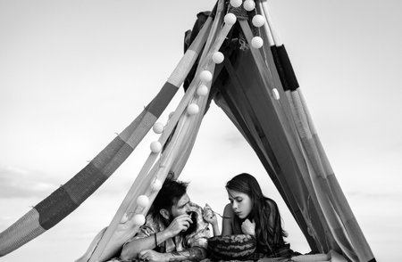 Family in tent. Couple in love hugging and kissing in camping. Smoking man eating woman at picnic...