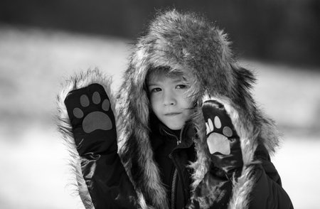 Funny little child boy in winter outdoor in frost snowy day outdoor. Cute kids face.