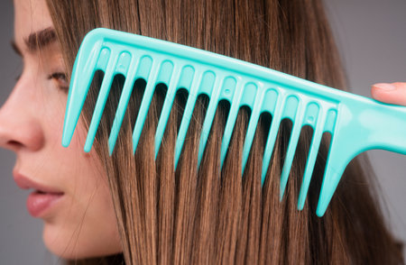 Close up woman combing hair. Macro hair comb combs hair. Haircare concept.の写真素材