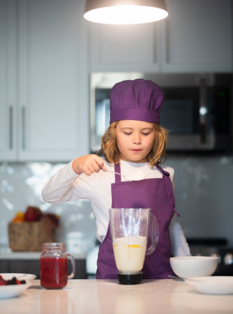 Kid cooking. Child chef cook is learning how to make a cake in the home kitchen.