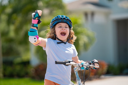 Kids first bike. Child learning to ride bike. Kid riding bike in a helmet. Child with a childs bike...