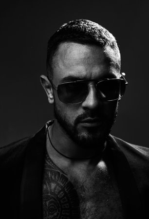 Metrosexual guy. Serious confident masculine glance. Fashion industry. Muscular athletic sexy male with tattoos. Confident and handsome brutal man. Male fashion. Attractive fashionable machoの写真素材