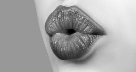 Girl kissing. Female lips kiss. Natural beauty lip care. Sexy female lips with pink lipstick. Sensual womens open mouths. Red lip with glossy lipgloss. Tongue and sexy.の写真素材