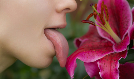 Tongue sensual lick orchid. Sexy woman mouth with tongue sticking out. Beautiful mouth close-up. Big...