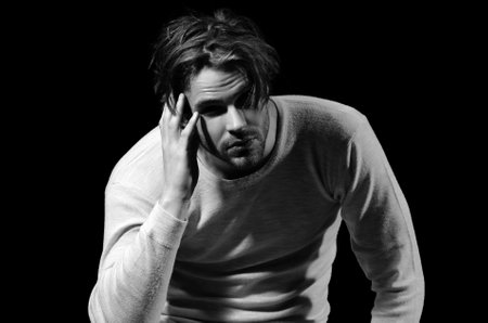 Fashion man. Handsome serious beauty male model portrait, young guy over black.の写真素材