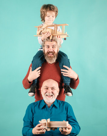Men generation: grandfather father and grandson are hugging looking at camera and smiling. Family adventure, imagination and innovation inspiration concept.の写真素材