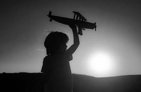 Dreaming kid. Boy pilot aviator with airplane. Dreams of traveling. Kids dream. Child on the background of sunset sky.の写真素材