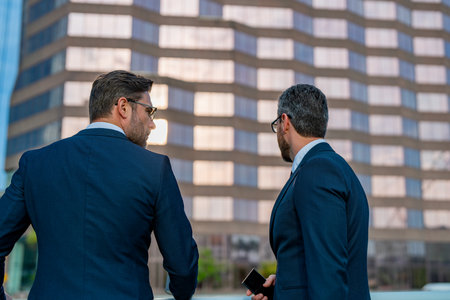 Mature businessman discuss information with colleague outdoor. Two business colleagues at meeting in american New York city. Successful project. Business ideas and opinions.の写真素材