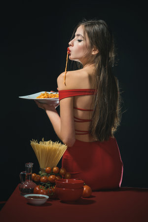 Sexy woman eat Pasta. Attractive Girl enjoying pasta. Pasta is delicious. Spaghetti is favorite dish. Sensual bite. Pasta is cooked to perfection. Love Italian cuisine. Savor taste Spaghetti.の写真素材