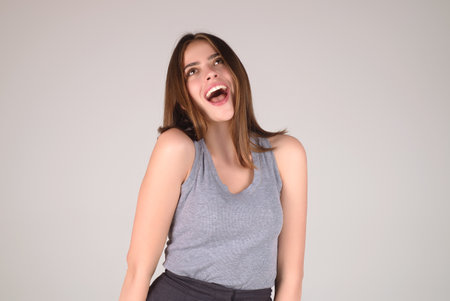 Cheerful excited woman celebrating success over studio blue isolated background. Excited winner. Excited girl with with wow face expression.の写真素材