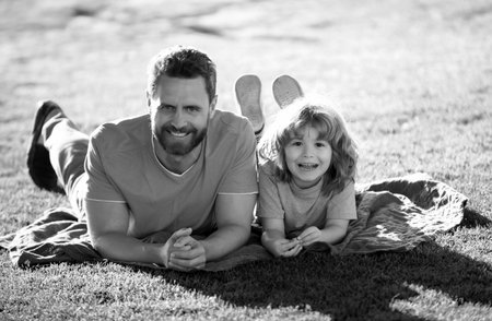 Concept of friendly family. Happy father and son enjoying summer time on vacation in a sunny park. Family camp, vacation, fathers day concept.の写真素材